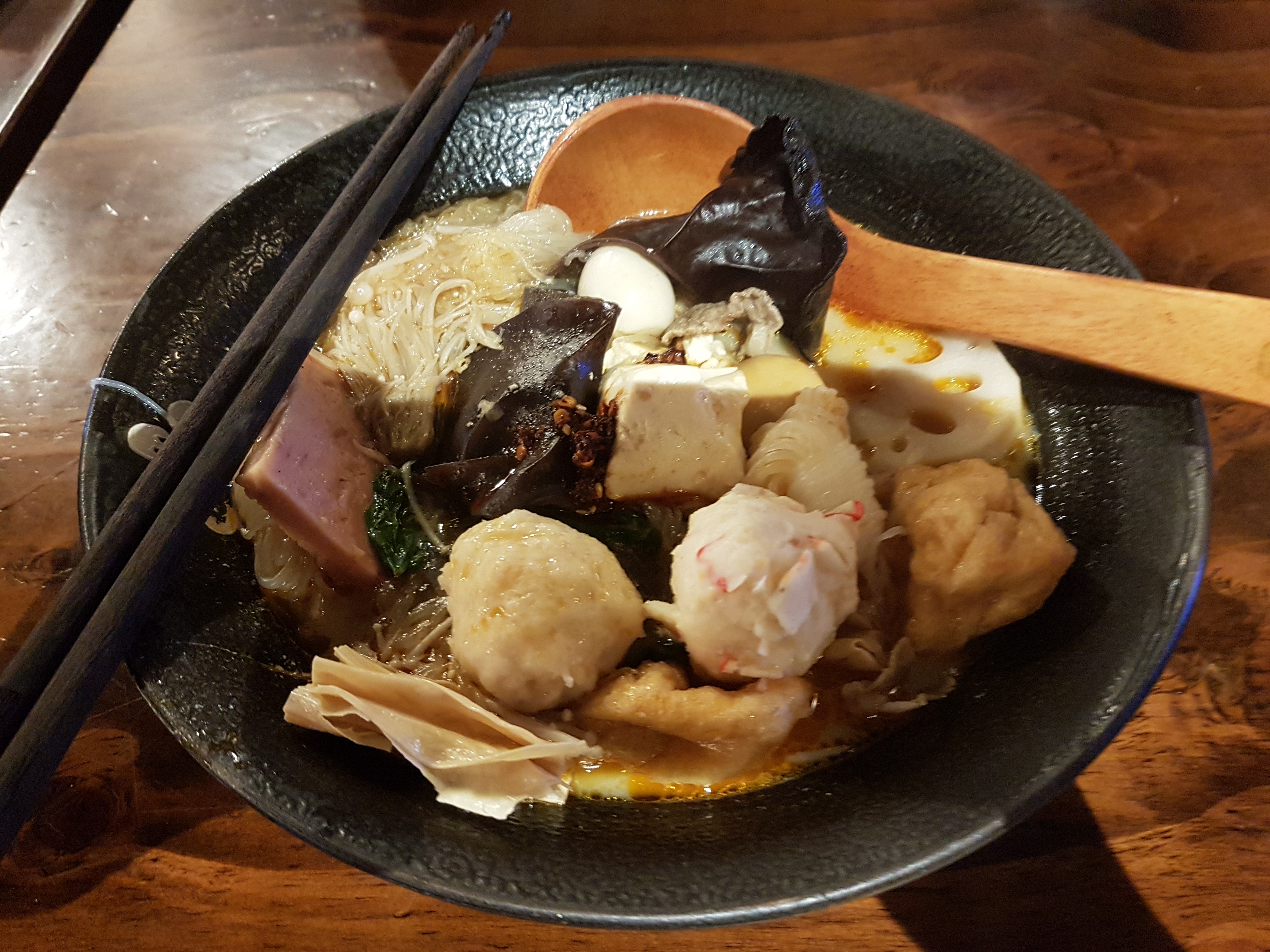 Panela de hot pot chinês com caldo e pimentas de Sichuan, pronta para uma refeição compartilhada.
