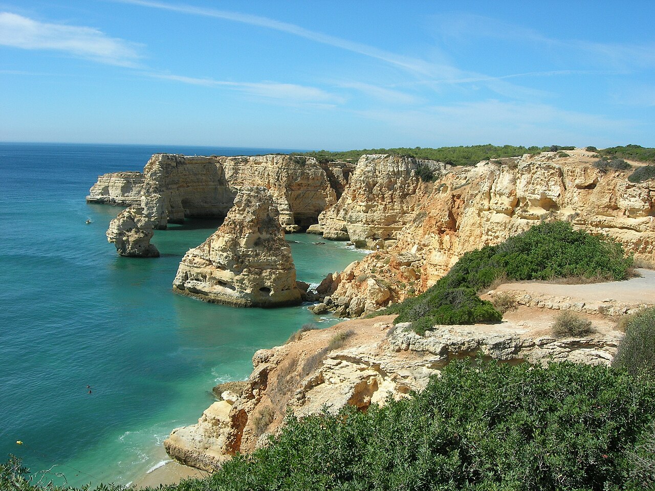 Praia da Marinha, no Algarve, com falésias douradas e águas azuladas.